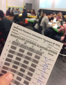 Students working in group quizzes using IF-AT cards (sample shown). 